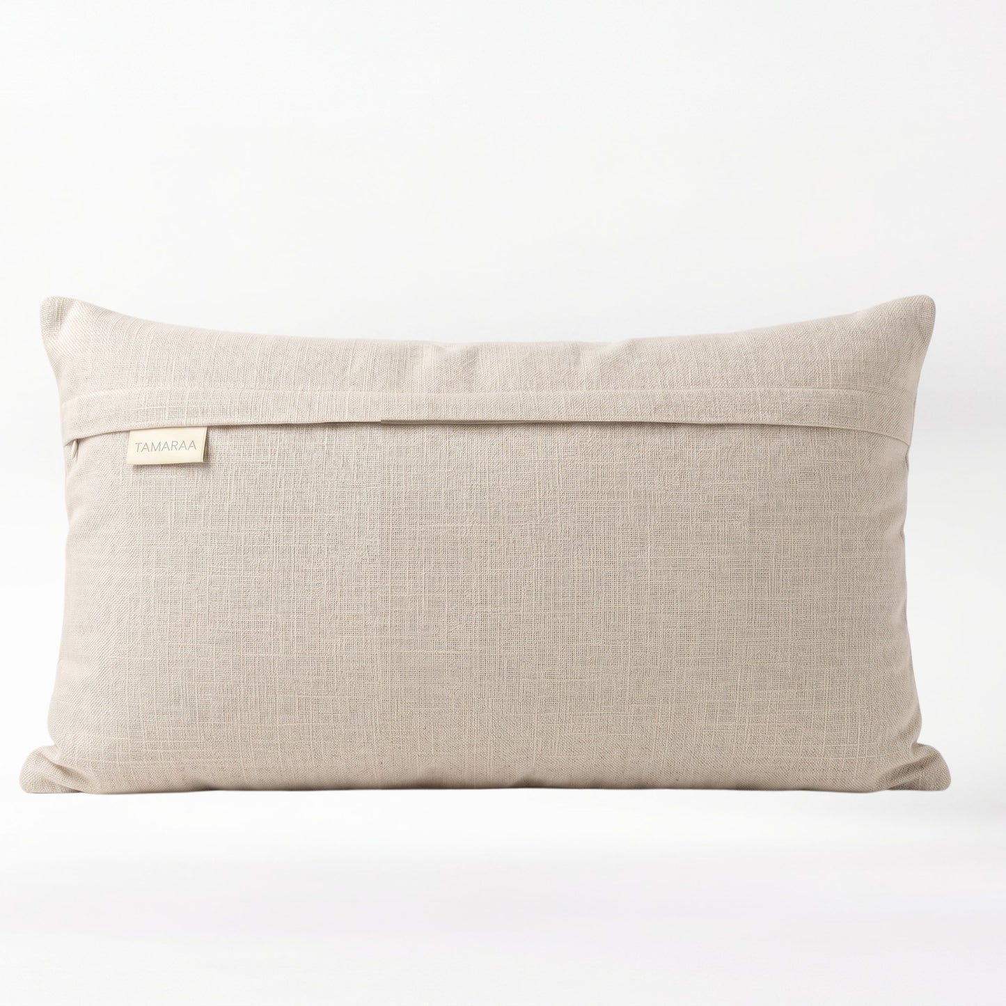 Beige pillow with a brand label on a white background